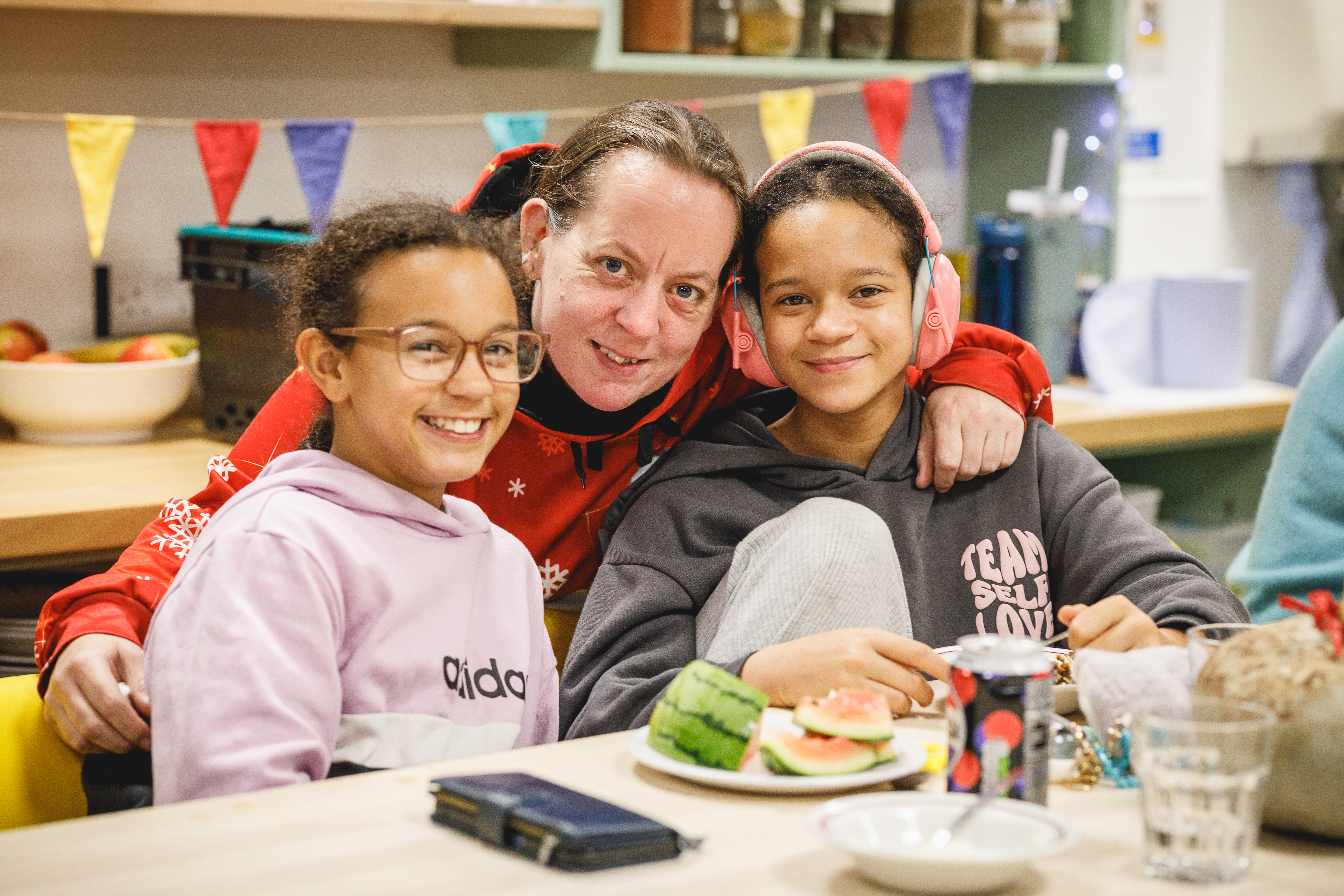 Parent and two children smiling at the camera at a party with food.jpg