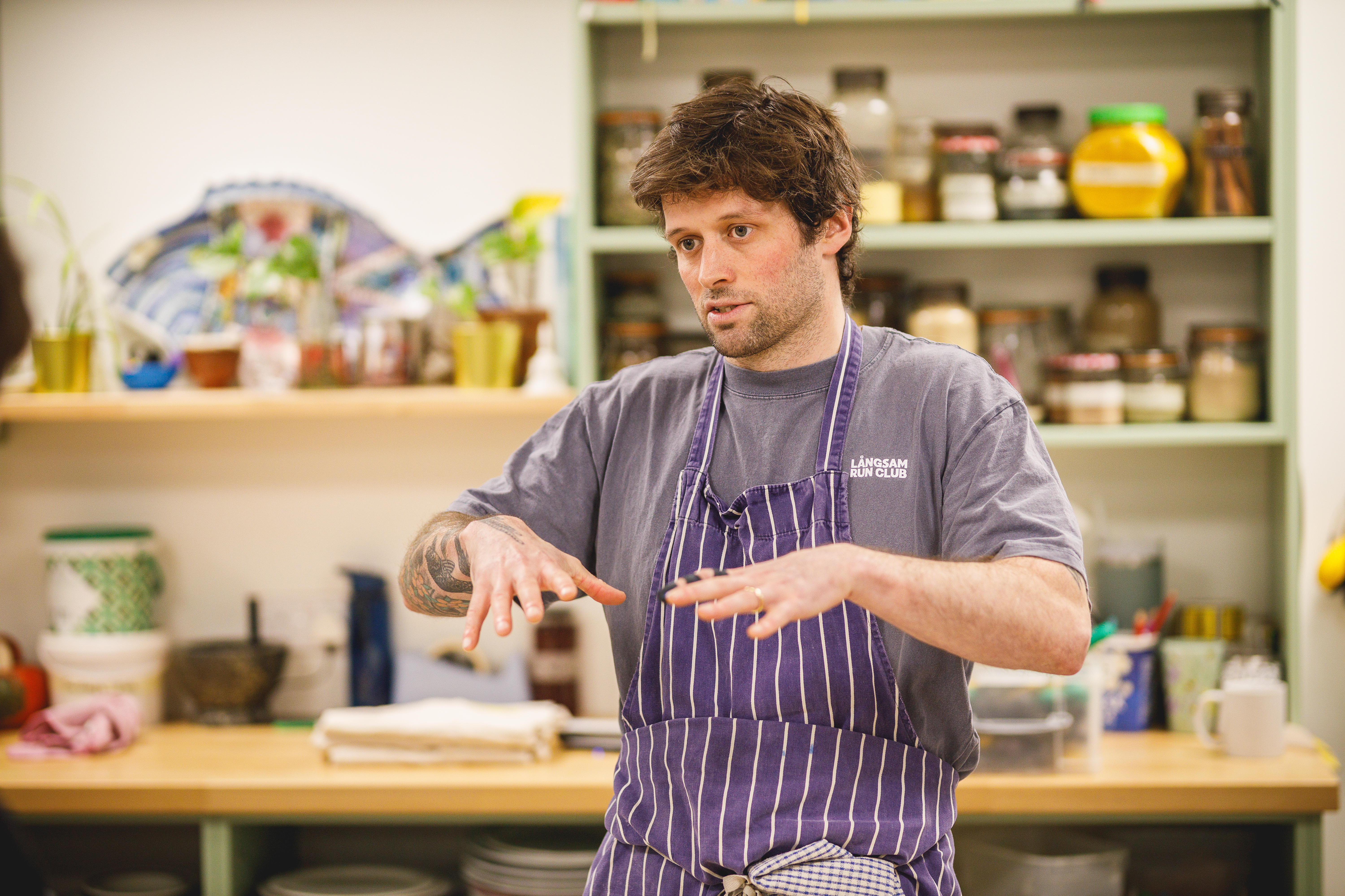 Cookery teacher Jesse with hands up teaching a class.jpg