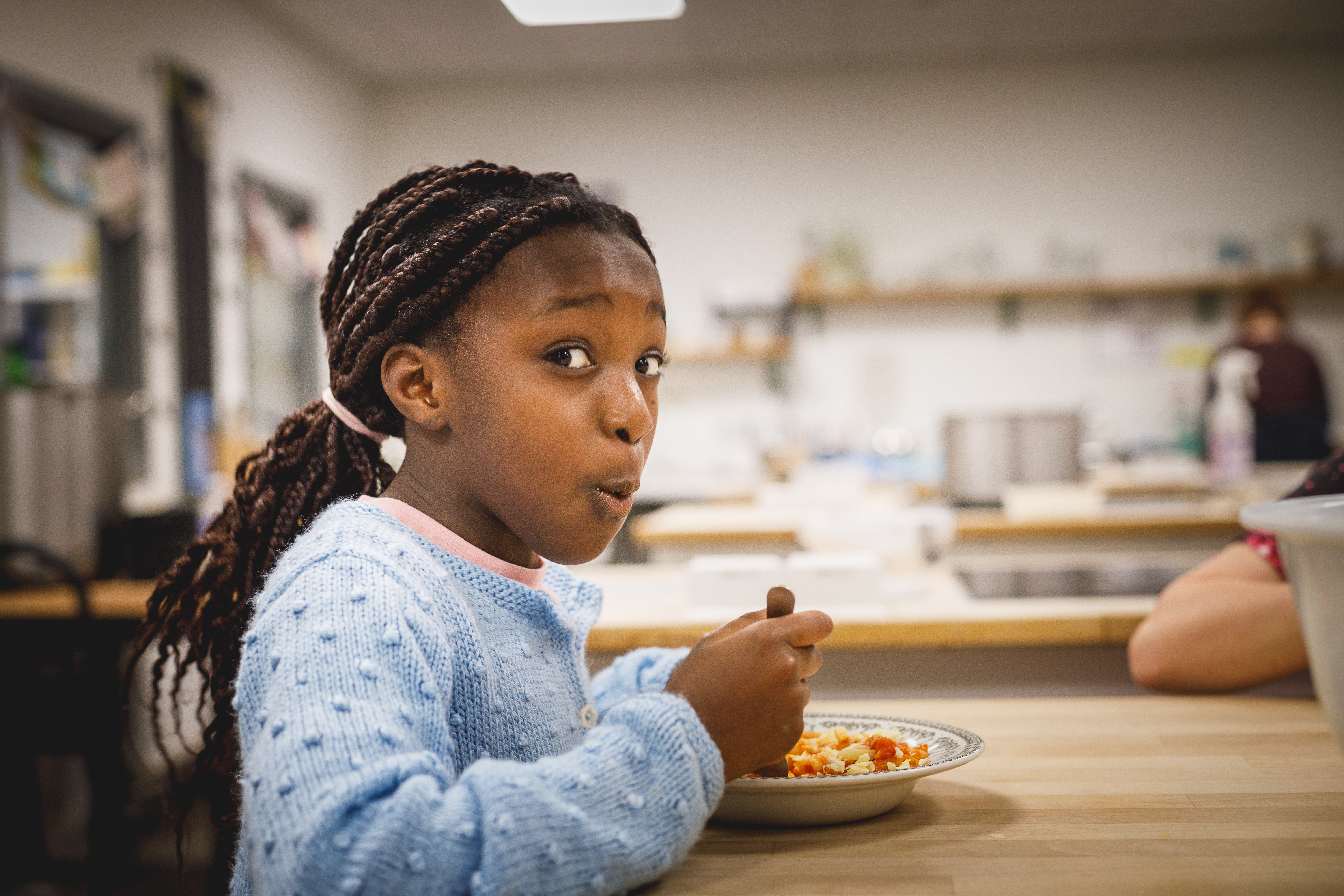 Young girl enjoying a plate of homecooked food.jpg