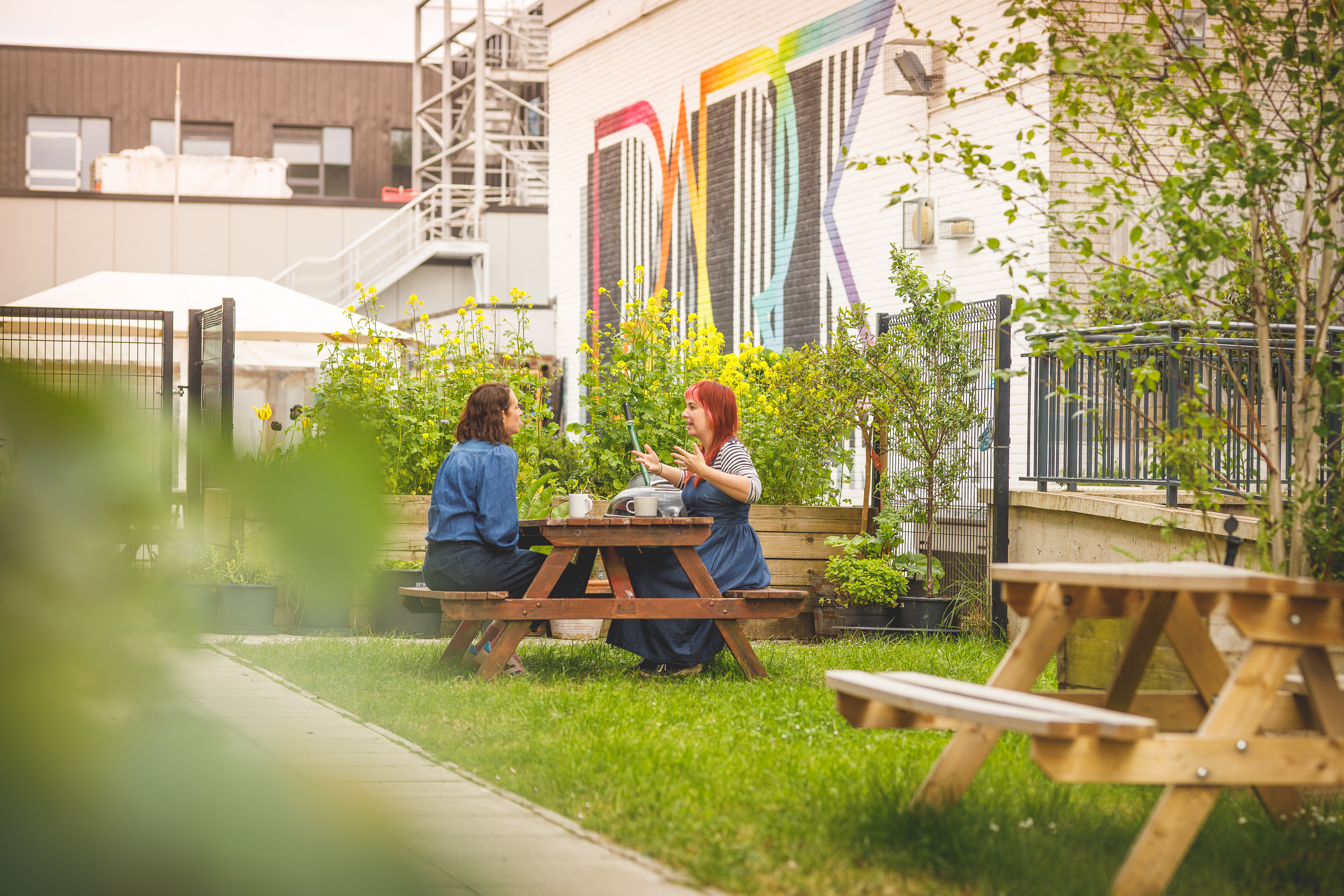 Two women sitting at a garden table chatting.jpg