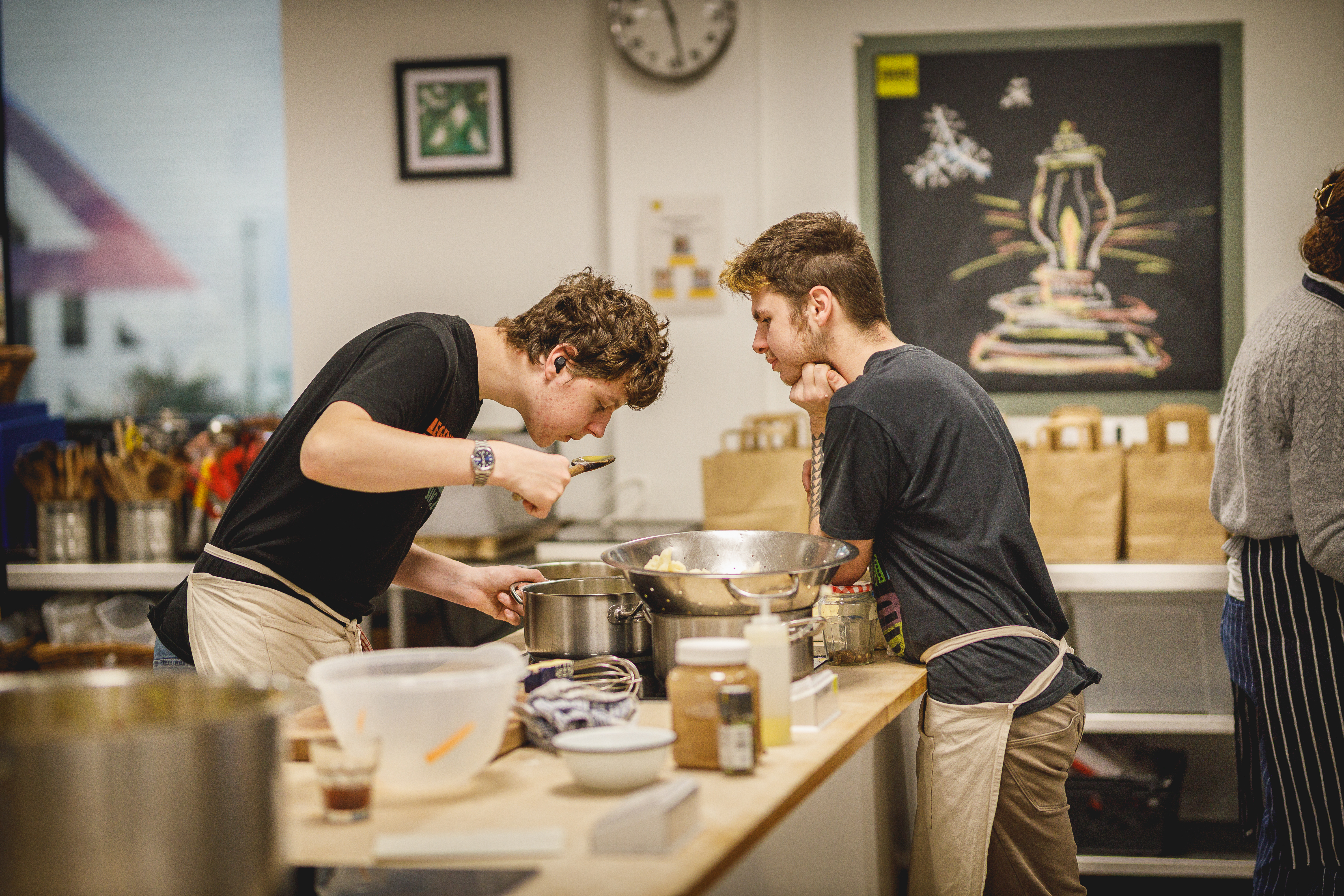 Two young adult chefs cooking together in the kitchen.jpg