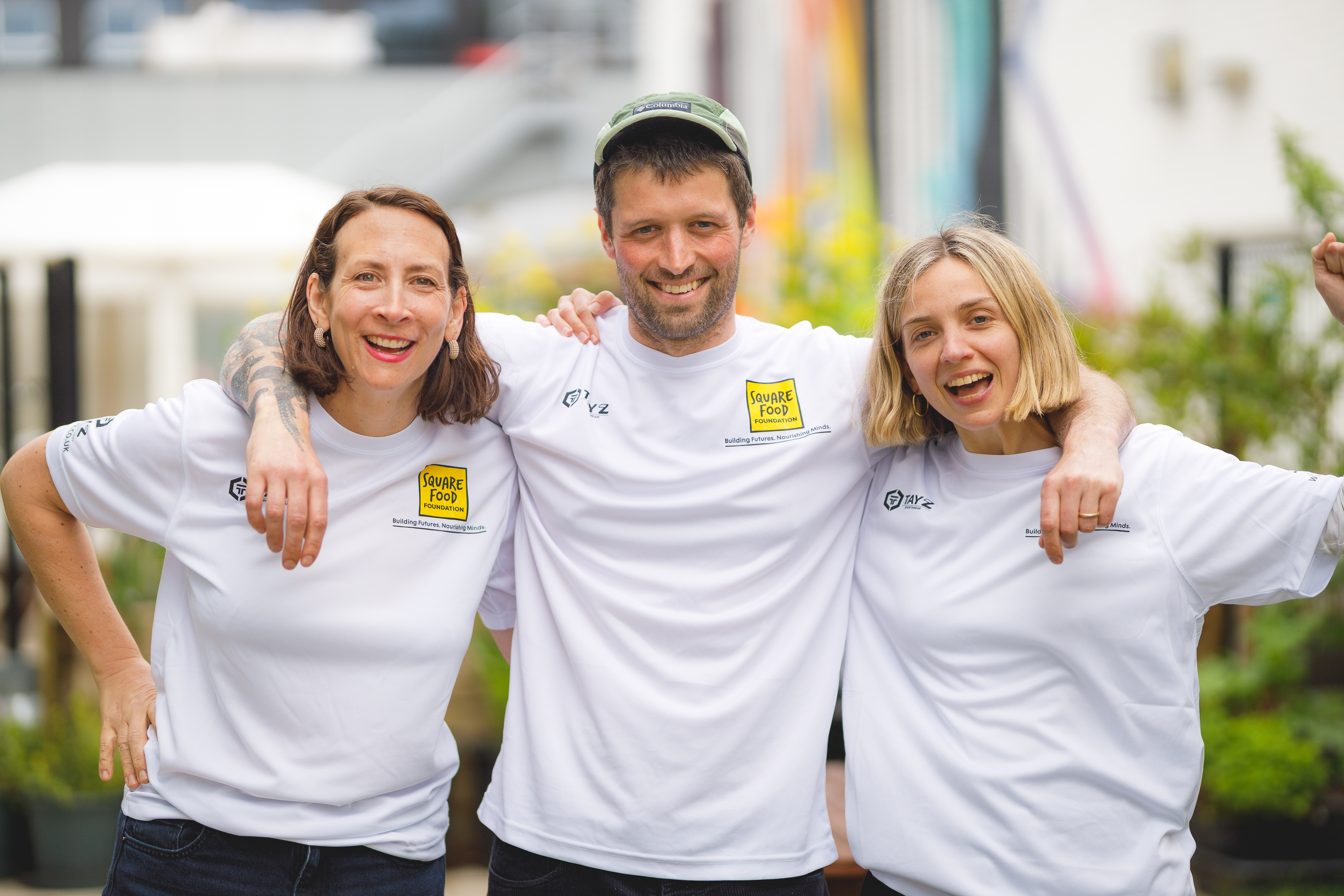 Three people smiling and posing for the camera in sports t-shirts.jpg