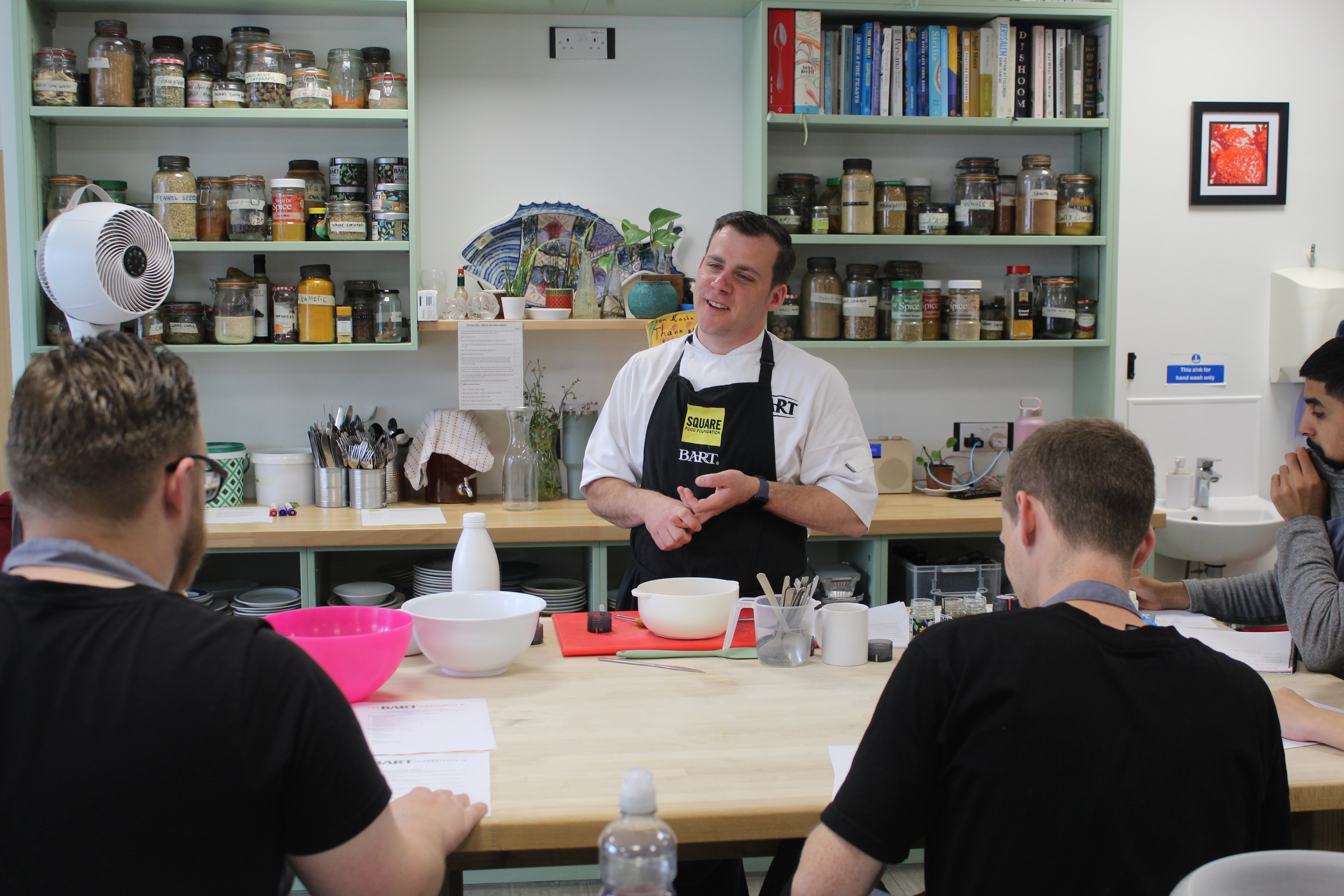 Chef with branded Barts Ingredients apron on teaching a class.JPG