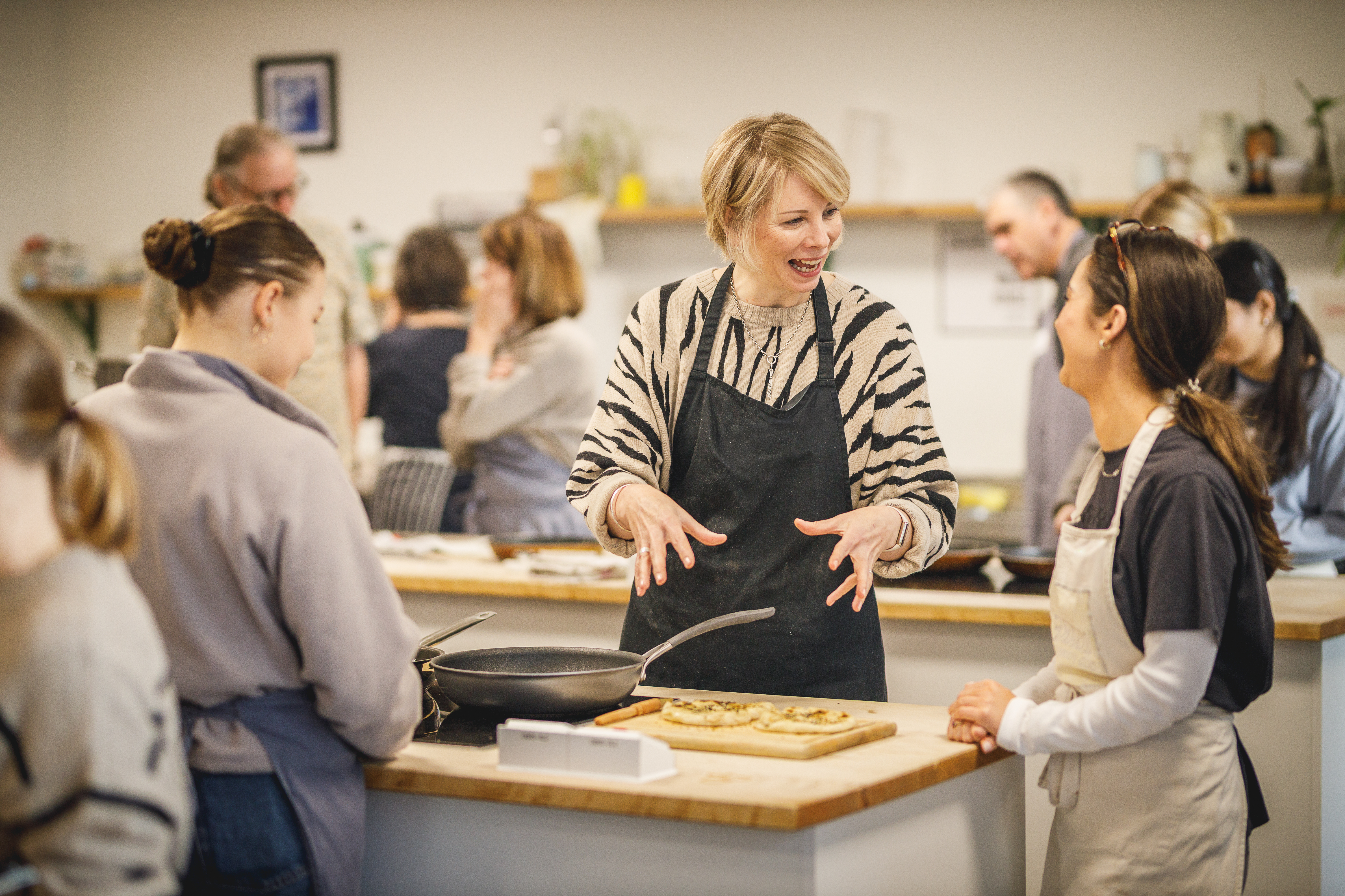 Several people in a kitchen cooking together and looking happy.jpg