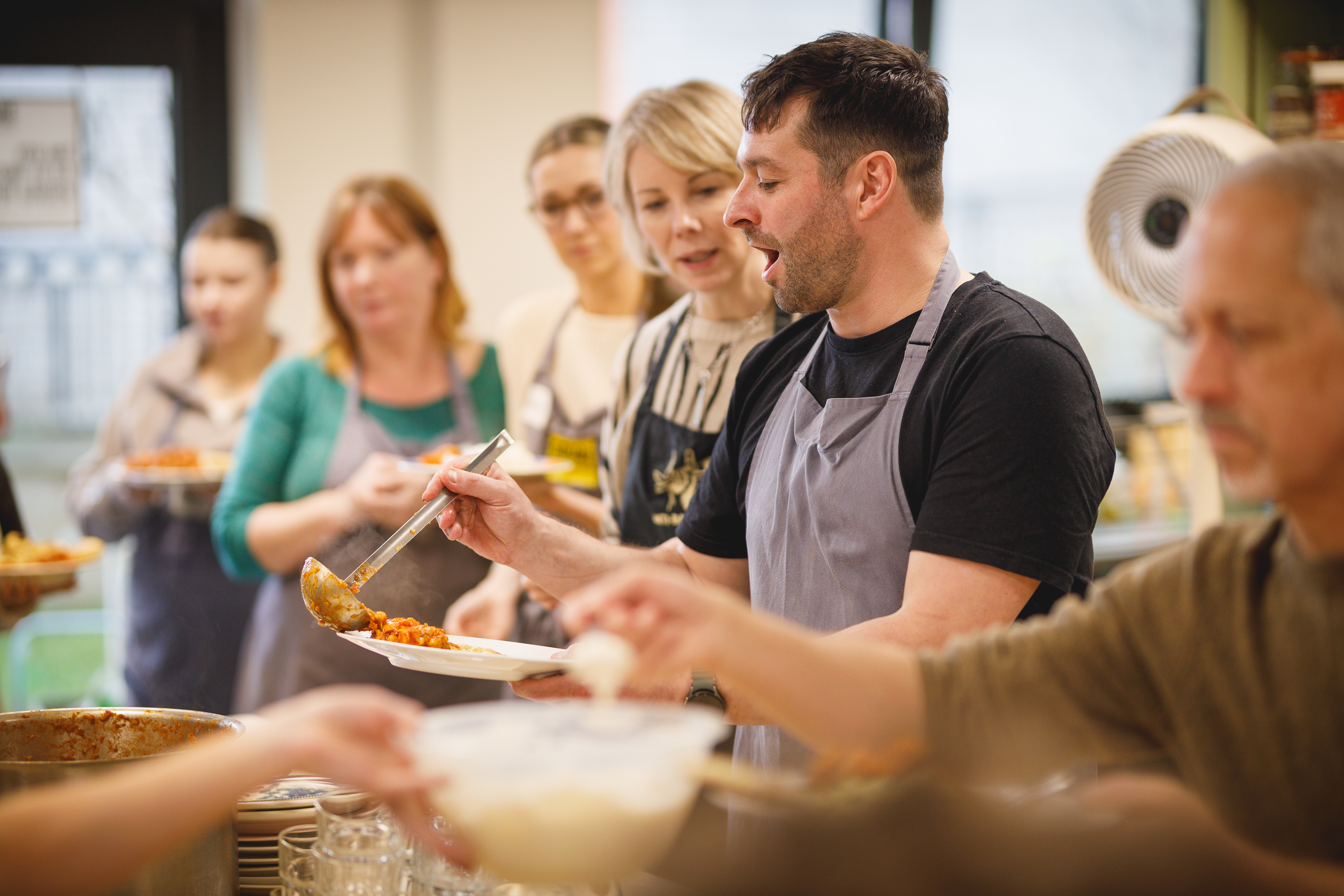 Group of people serving themselves food at a team building event.jpg