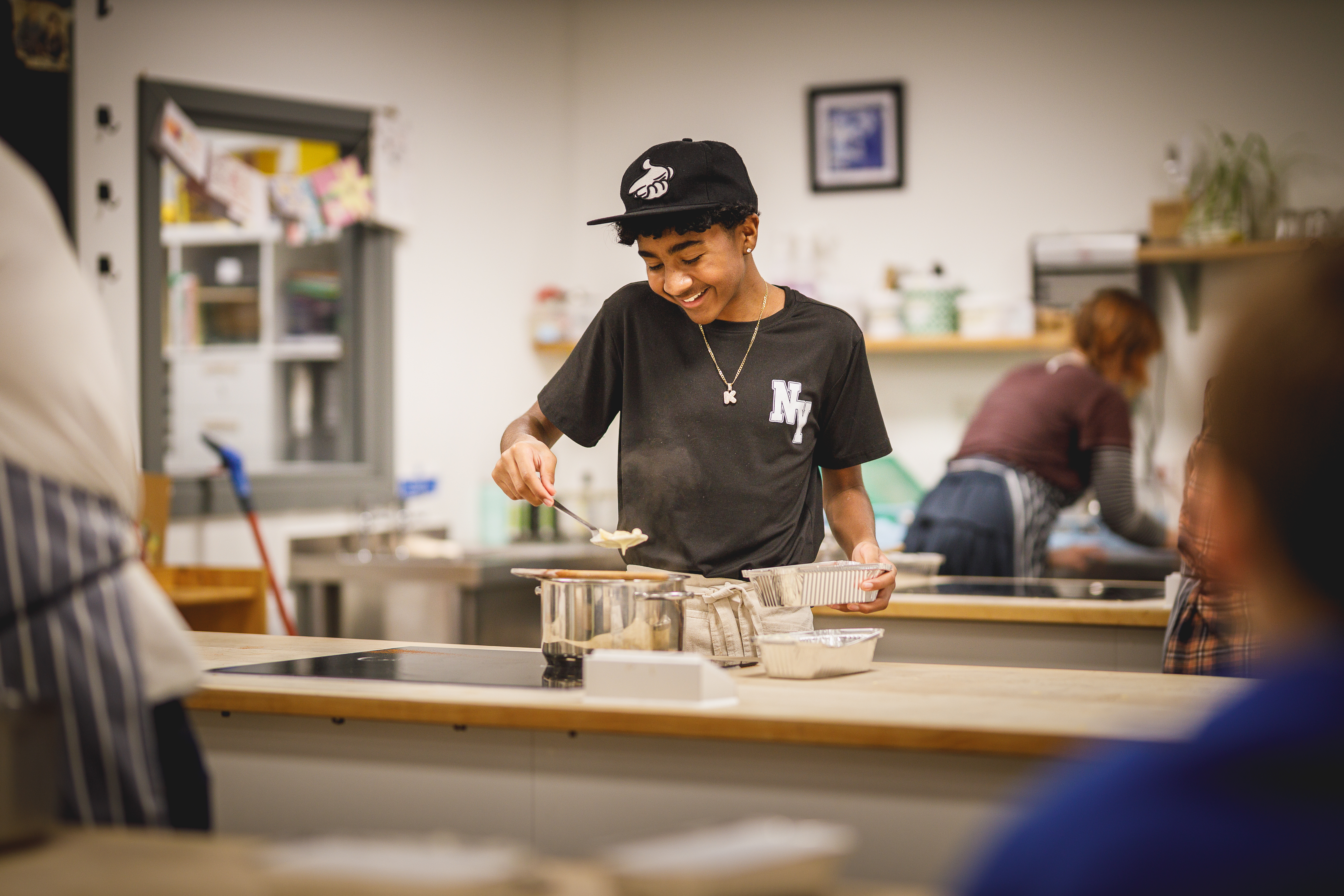 boy in black cap cooking in kitchen.jpg