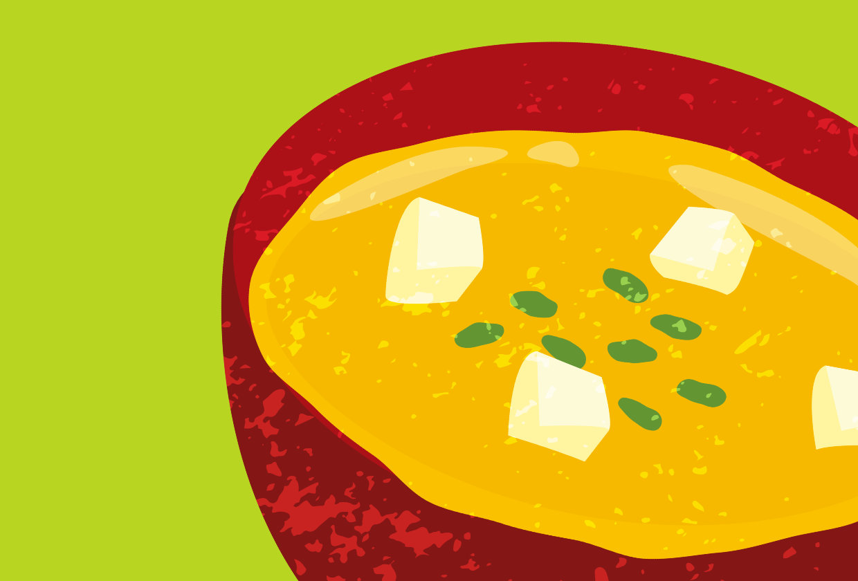 illustration of orange coloured soup in a red bowl on a green background 