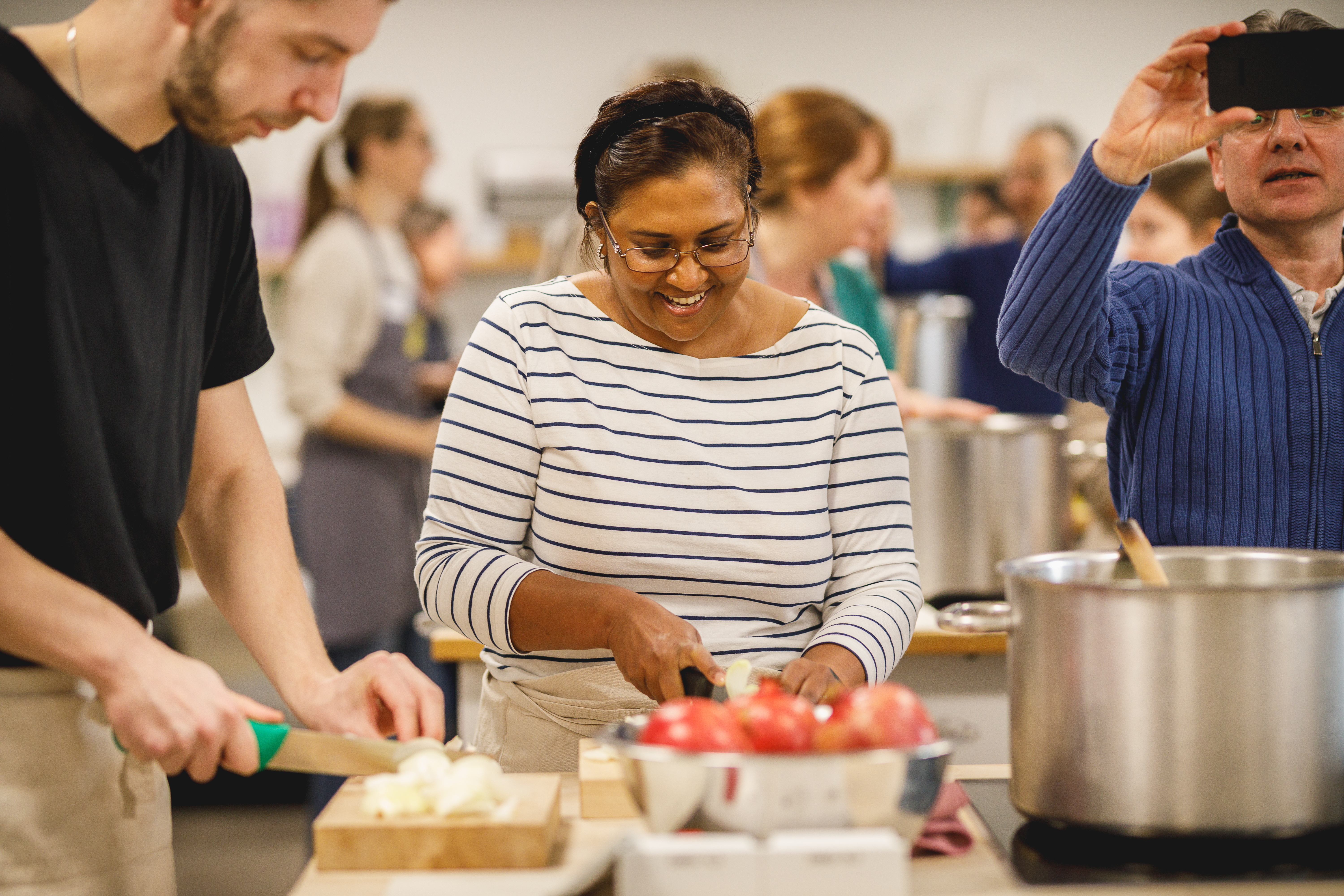 Happy woman in striped top chopping ingredients in kitchen.jpg