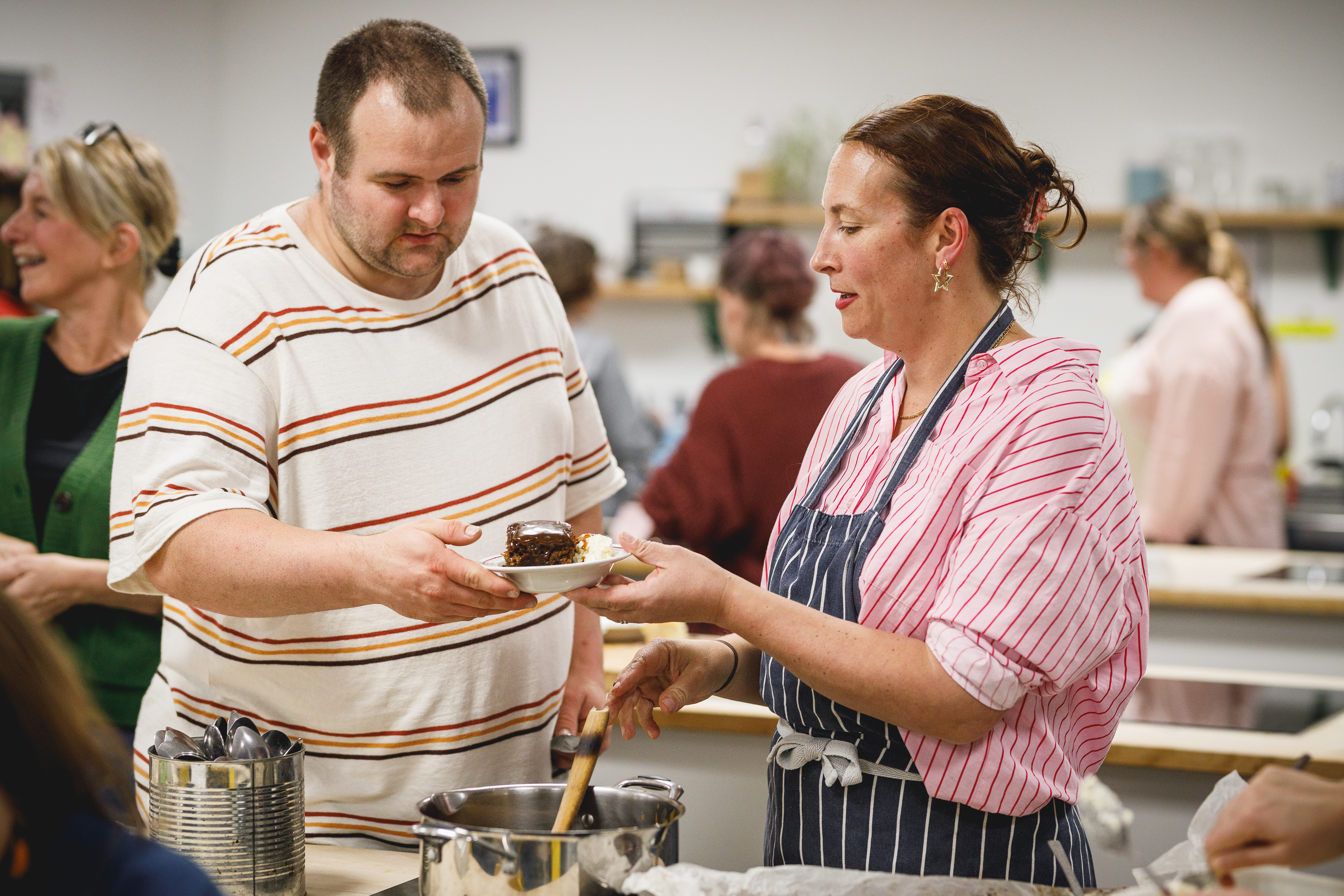 Teacher Charlotte serving pudding to man.jpg